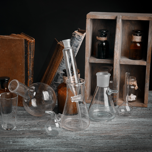 Tisch mit Glasflaschen und Destillationsausrüstung
